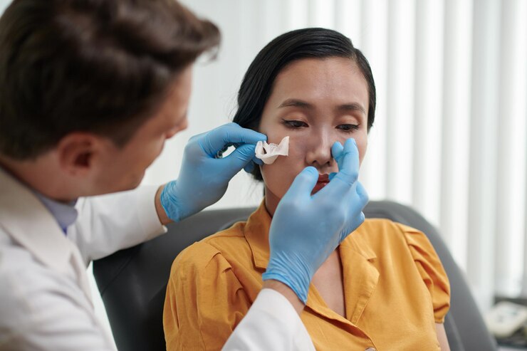 plastic-surgeon-examining-nose-patient-after-rhinoplasty_274689-44748