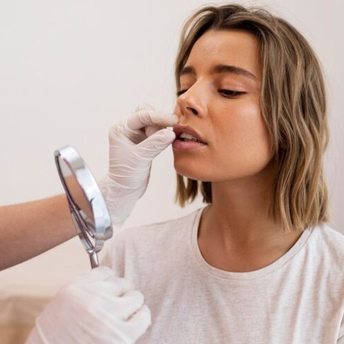 close-up-woman-looking-mirror-after-lip-filler_23-2149313547