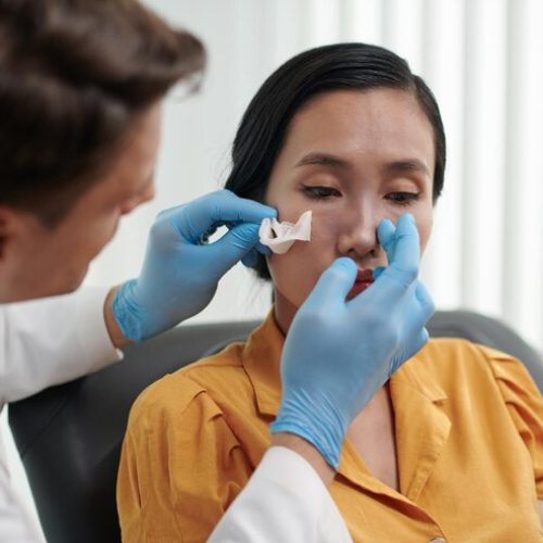 plastic-surgeon-examining-nose-patient-after-rhinoplasty_274689-44748